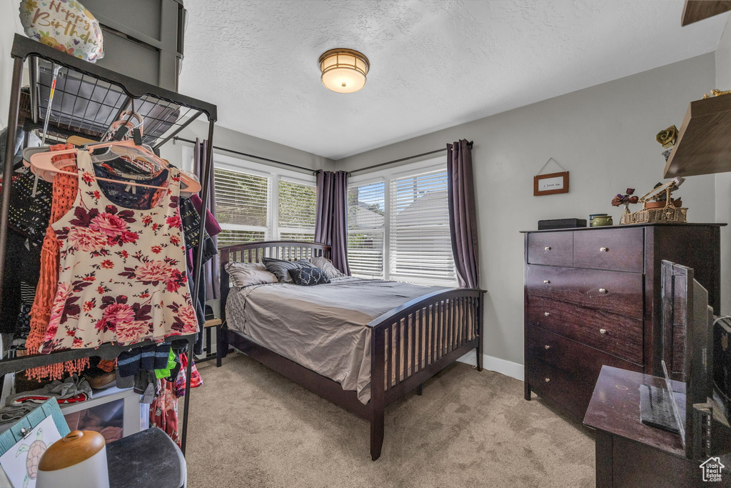 Bedroom featuring light carpet and a textured ceiling