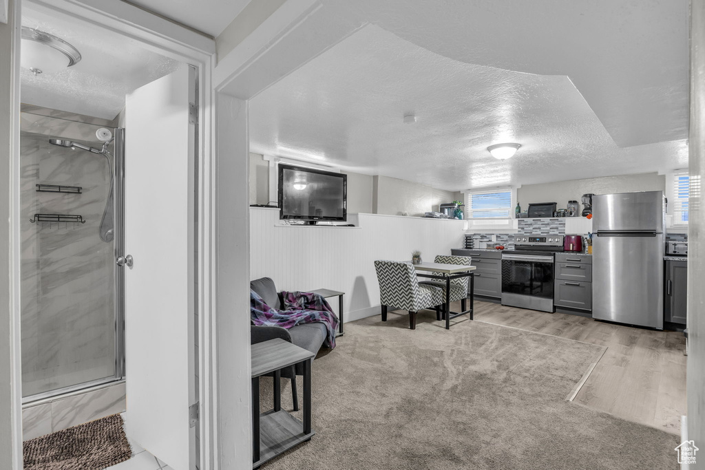 Carpeted living room featuring a textured ceiling and a healthy amount of sunlight