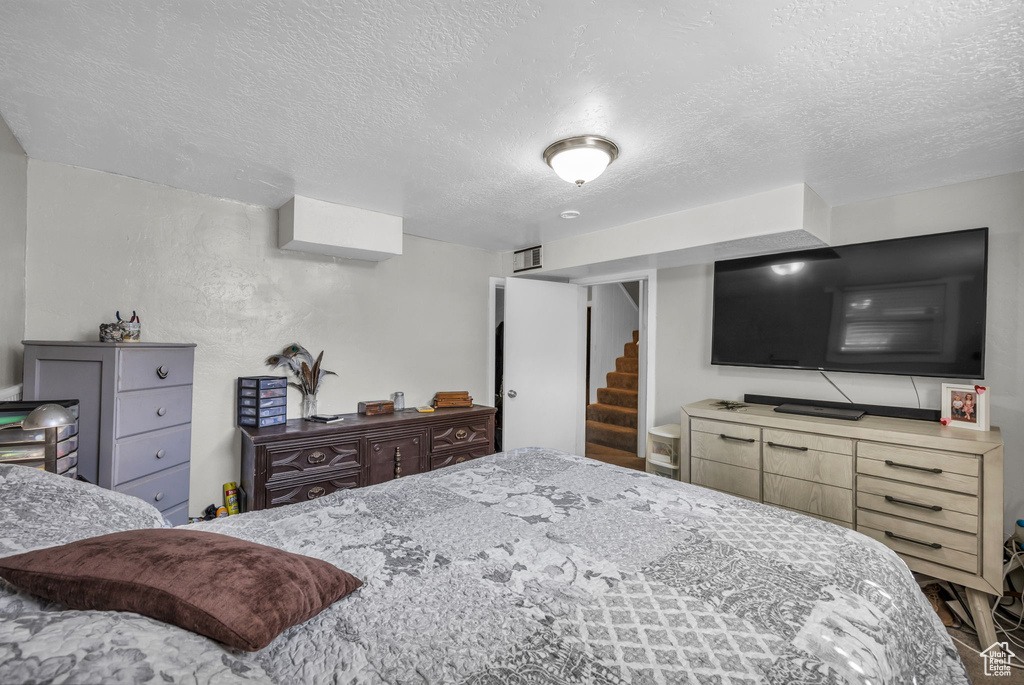 Bedroom with a textured ceiling and hardwood / wood-style floors