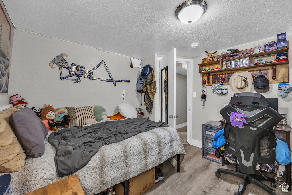 Bedroom featuring a textured ceiling and light wood-type flooring