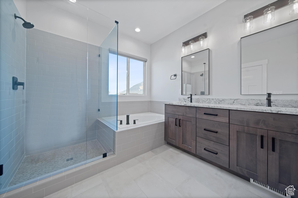 Bathroom with tile patterned flooring, vanity, and shower with separate bathtub