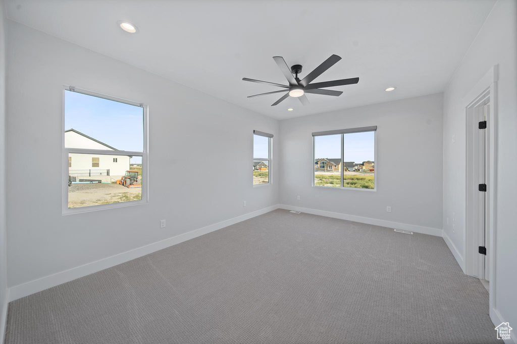 Carpeted spare room with ceiling fan