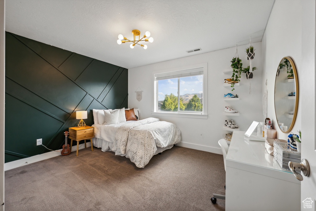 Carpeted bedroom featuring an inviting chandelier and vaulted ceiling