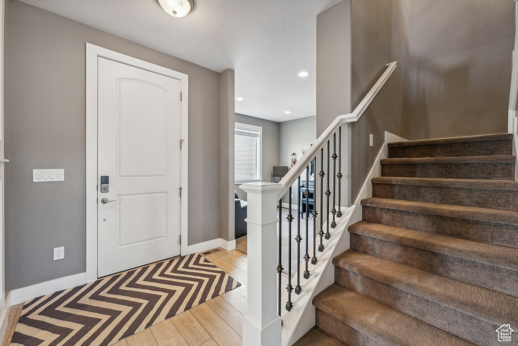 Foyer featuring light wood-type flooring and a textured ceiling