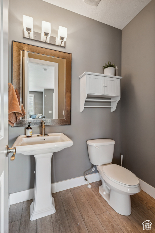 Bathroom featuring a textured ceiling, toilet, and hardwood / wood-style floors