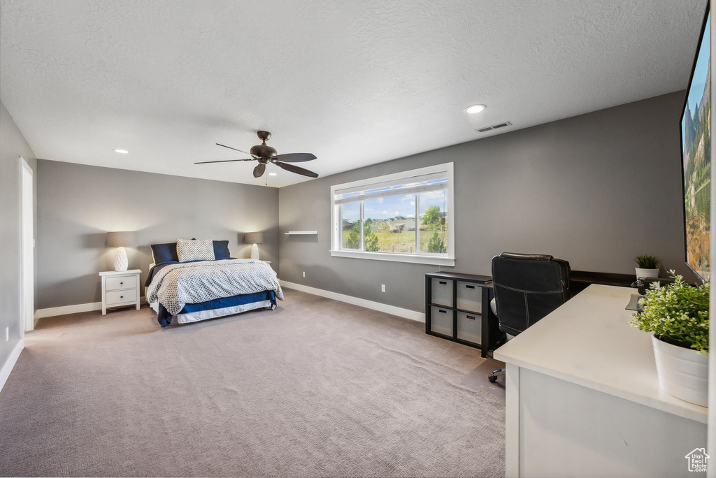 Bedroom with carpet flooring, ceiling fan, and a textured ceiling