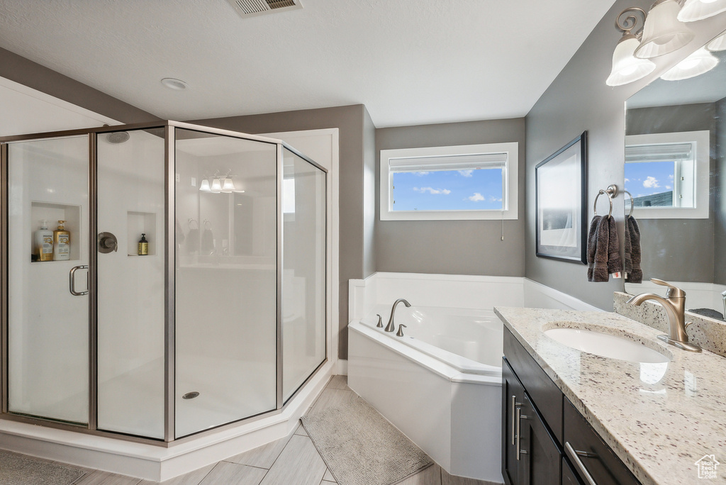 Bathroom featuring plus walk in shower and vanity