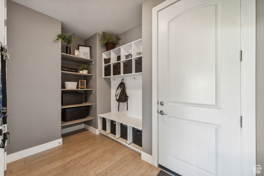 Mudroom featuring light wood-type flooring and a textured ceiling