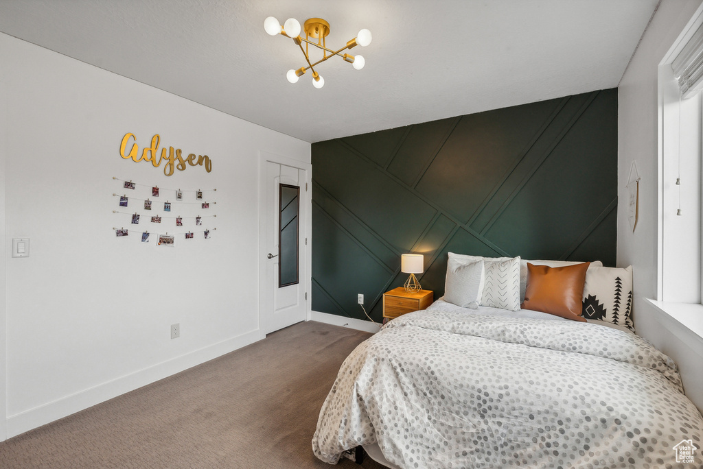 Bedroom with a chandelier and carpet