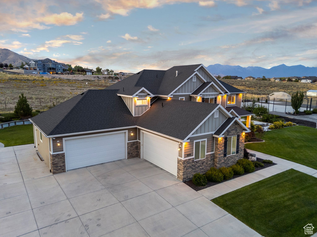 Craftsman inspired home featuring a yard, a garage, and a mountain view