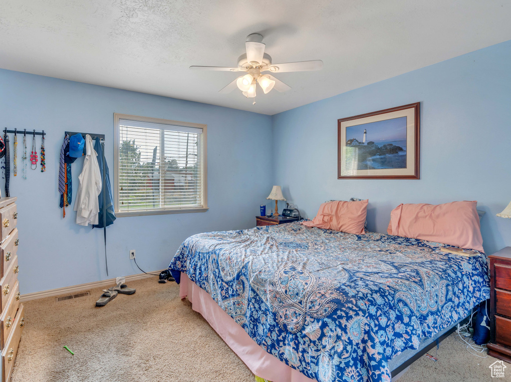 Carpeted bedroom featuring ceiling fan