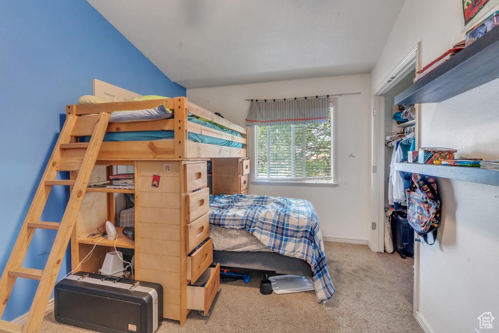 Carpeted bedroom with vaulted ceiling and a closet