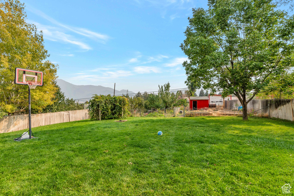 View of yard with a mountain view and a storage unit