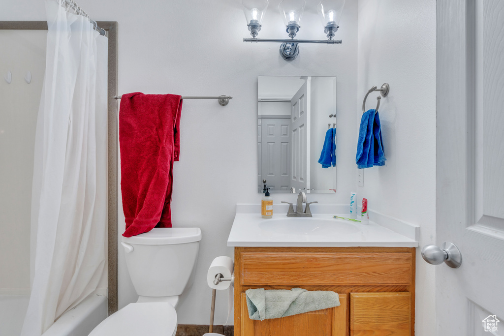 Full bathroom with vanity, toilet, and shower / tub combo with curtain