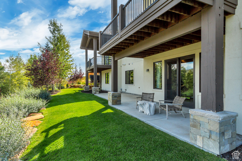 View of yard with a balcony and a patio