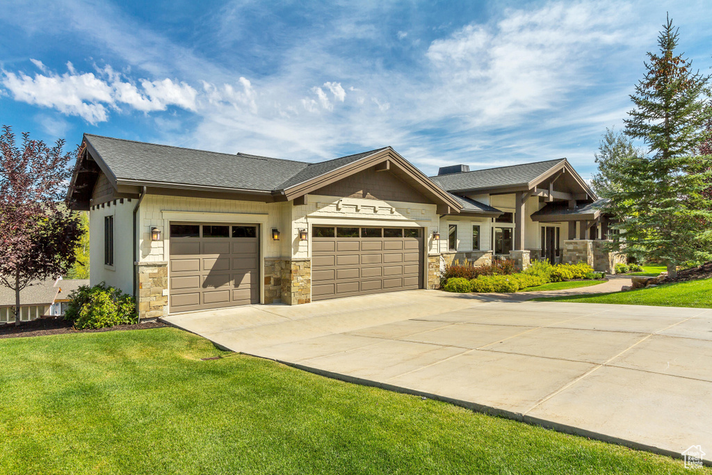 Craftsman-style house featuring a garage and a front lawn