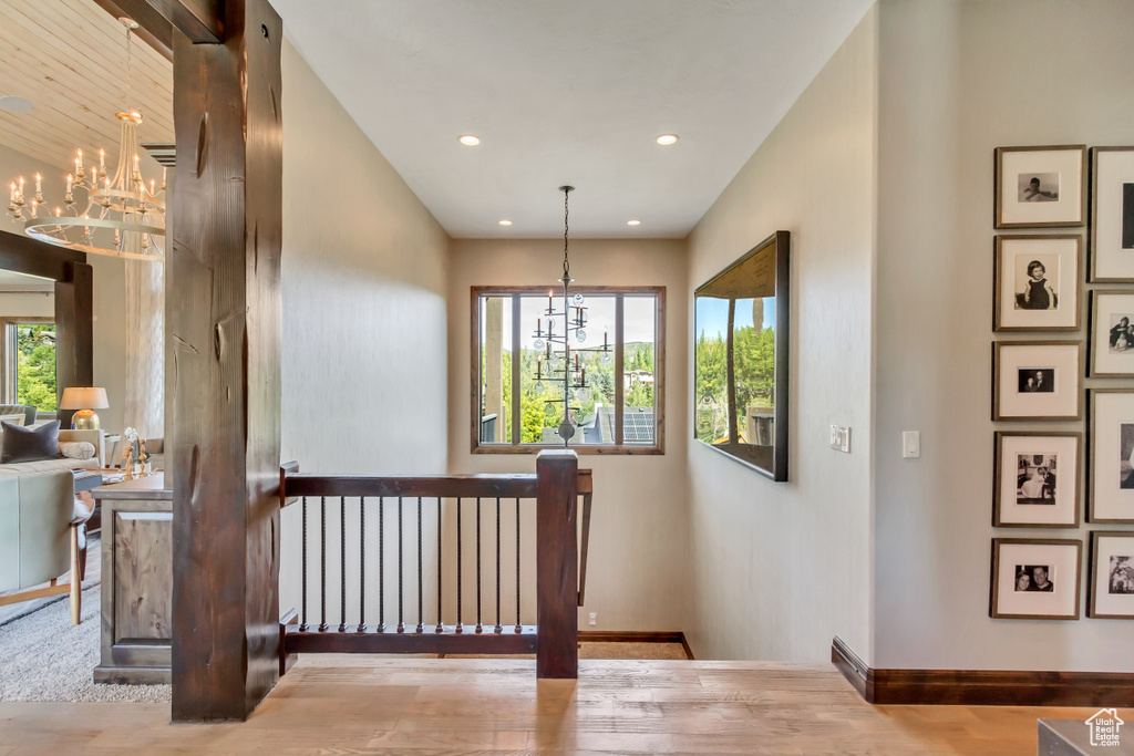 Staircase featuring hardwood / wood-style floors and an inviting chandelier