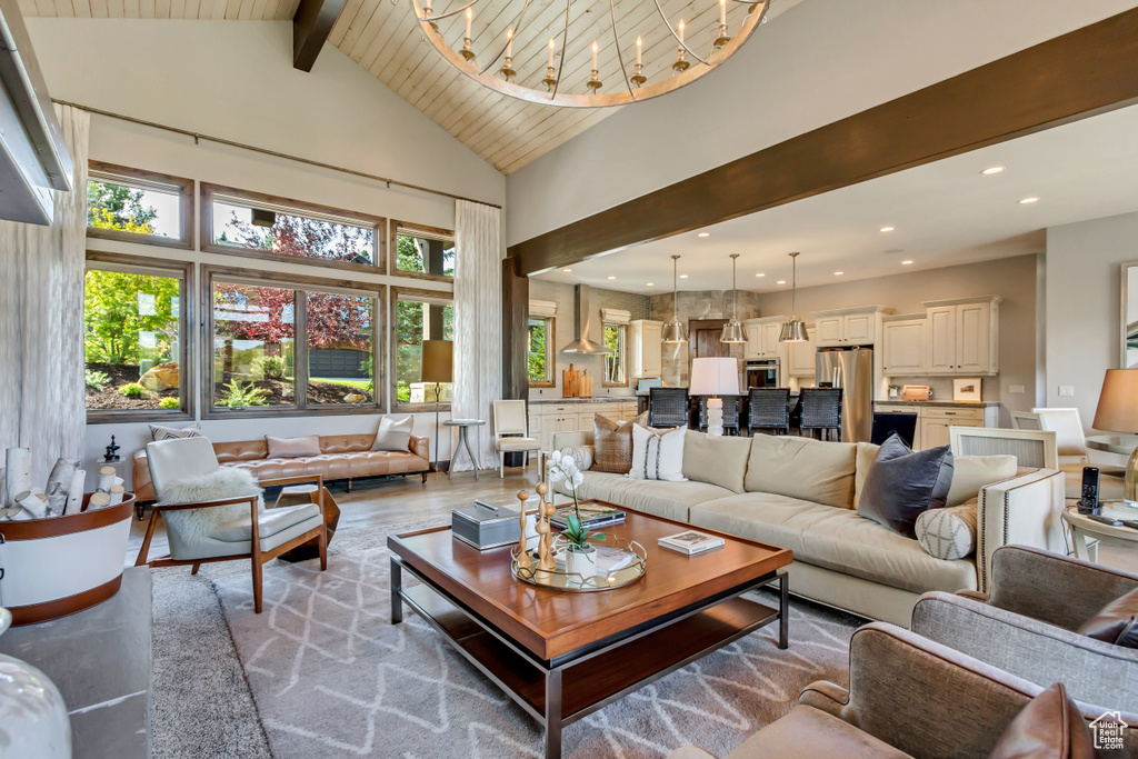 Living room featuring high vaulted ceiling, beam ceiling, and a healthy amount of sunlight