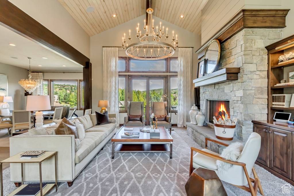 Carpeted living room with a stone fireplace, high vaulted ceiling, an inviting chandelier, and a healthy amount of sunlight