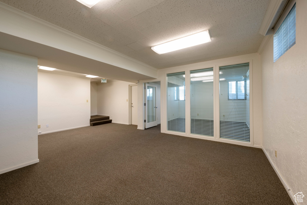 Unfurnished room with dark carpet and ornamental molding