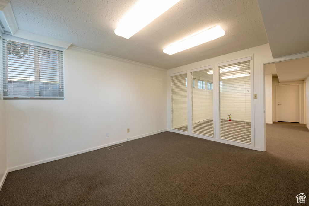 Carpeted spare room featuring a textured ceiling