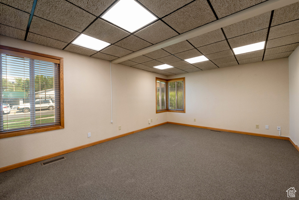 Spare room featuring a drop ceiling and carpet floors