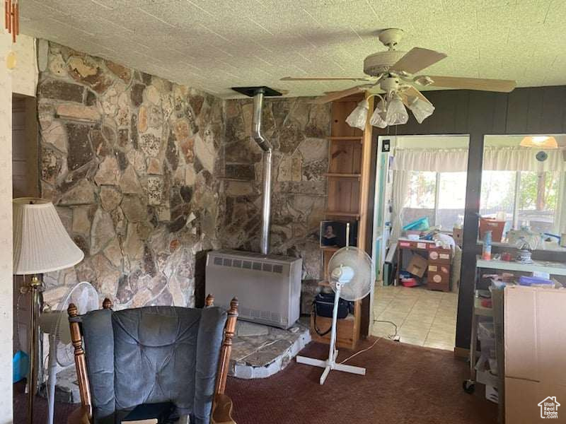 Carpeted dining space with heating unit and ceiling fan