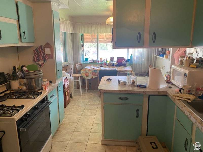 Kitchen featuring white appliances and light tile patterned flooring