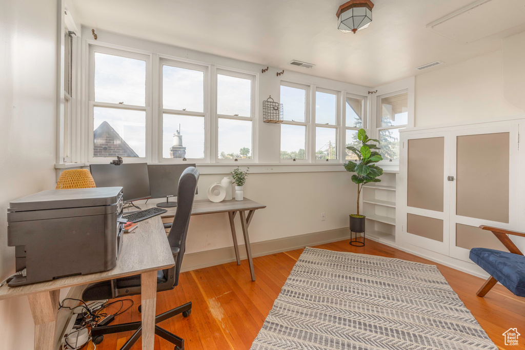 Home office with light hardwood / wood-style flooring