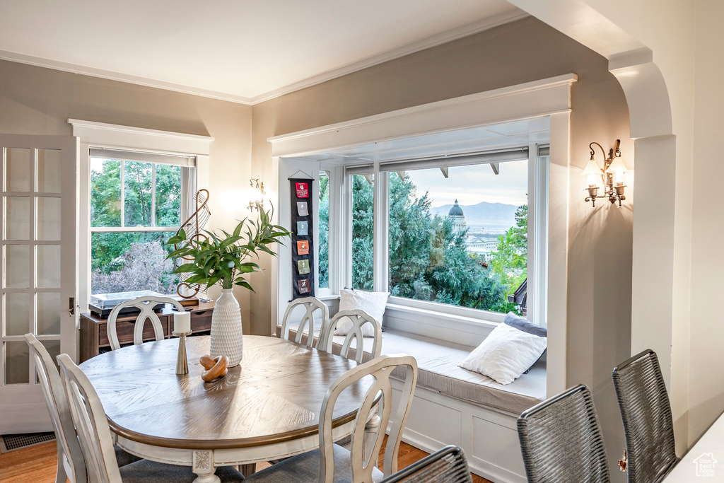 Dining room with wood-type flooring, ornamental molding, and breakfast area