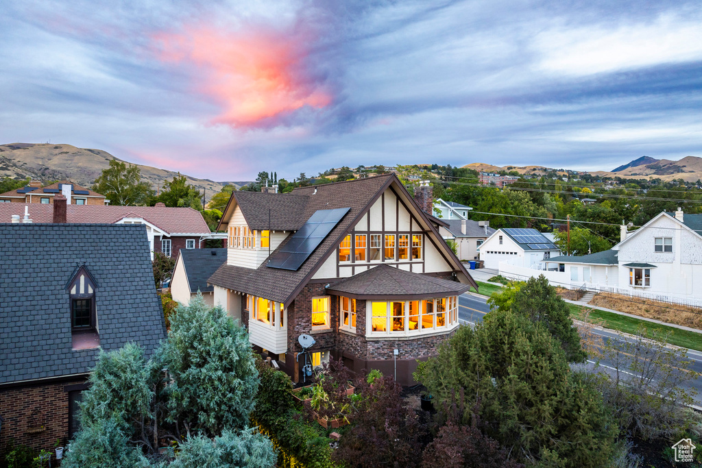 Back house at dusk featuring a mountain view