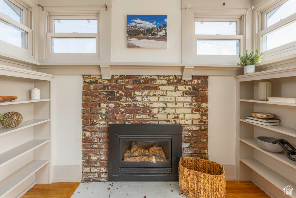 Interior details featuring a brick fireplace and hardwood / wood-style floors