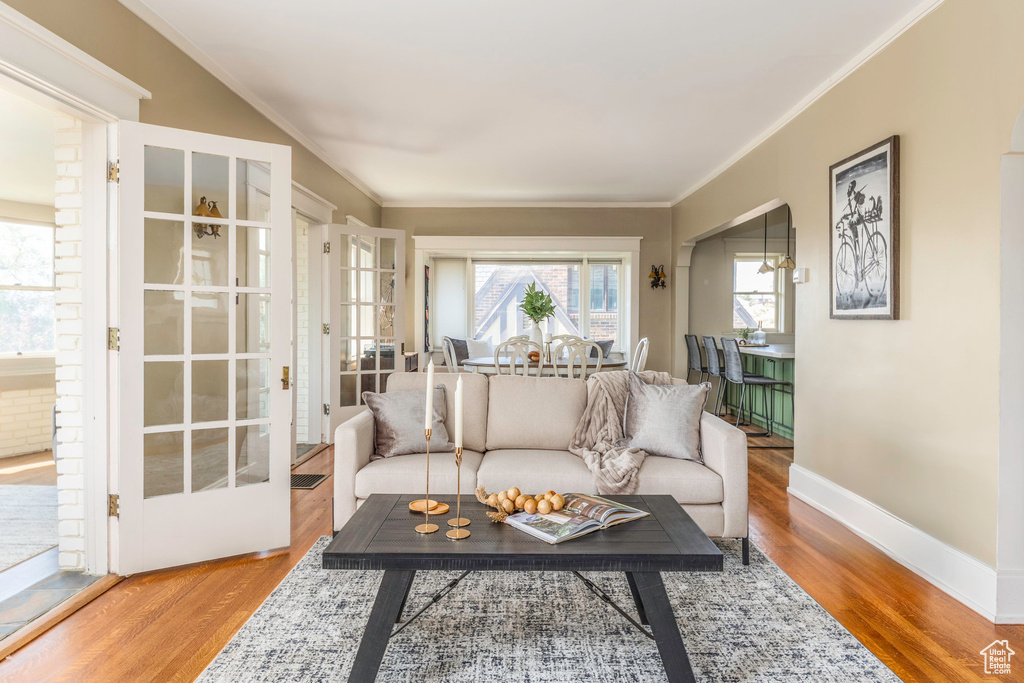 Living room with wood-type flooring and crown molding