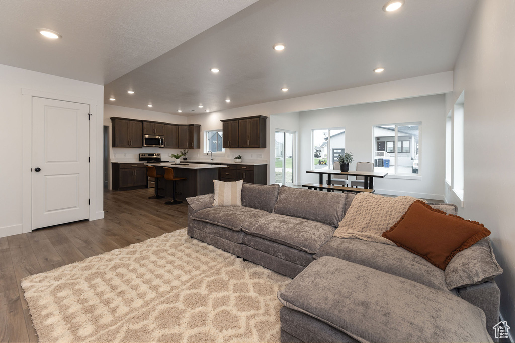 Living area with dark wood-style flooring, baseboards, and recessed lighting