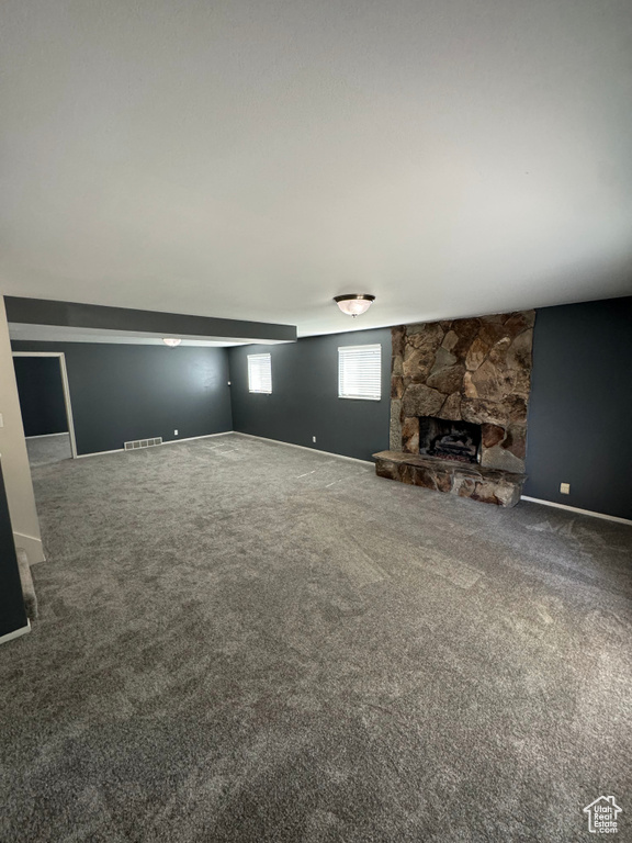 Unfurnished living room with carpet and a fireplace