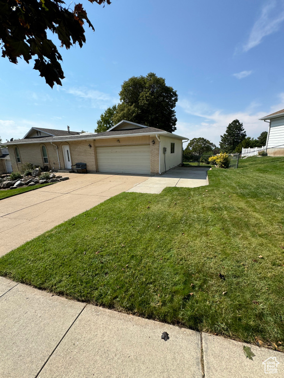 Ranch-style home with a garage and a front lawn