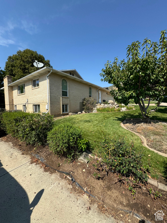 View of property exterior with a lawn