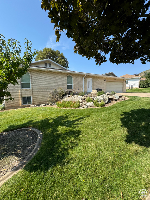 Single story home featuring a front lawn and a garage