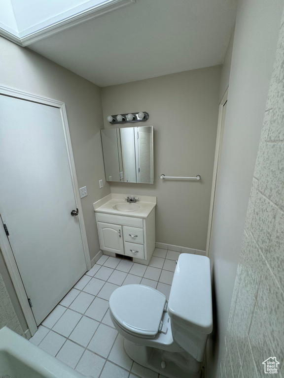 Bathroom featuring tile patterned floors, toilet, and vanity