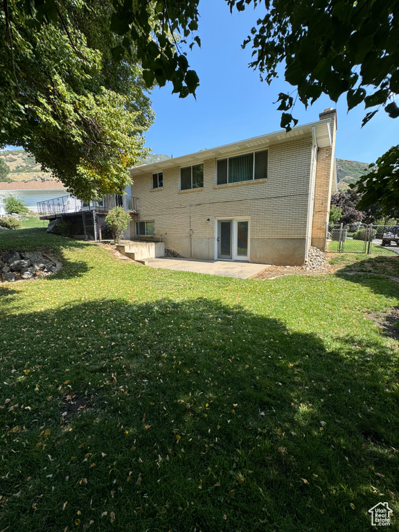 Rear view of property with a water view and a lawn