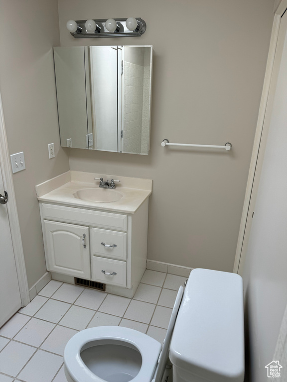 Bathroom featuring tile patterned floors, toilet, and vanity