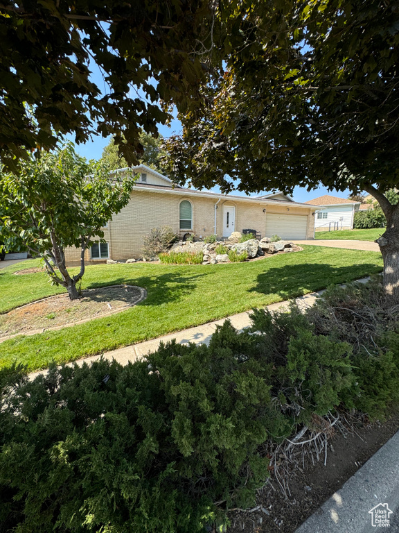 View of front of home featuring a garage and a front lawn