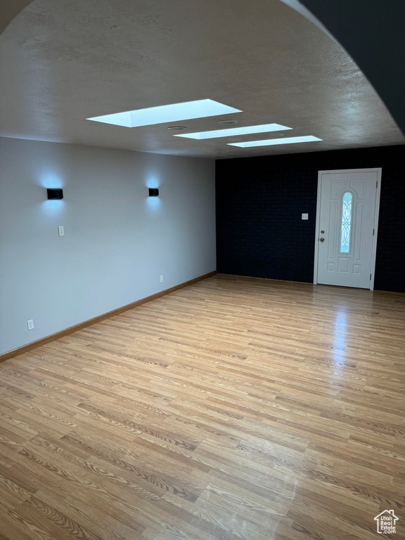 Interior space with light hardwood / wood-style floors and a skylight