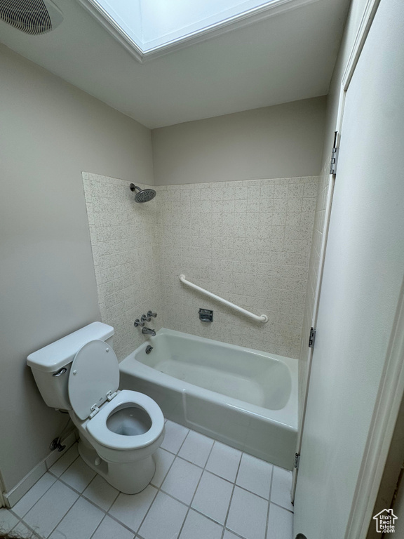 Bathroom with tile patterned flooring, toilet, and tiled shower / bath