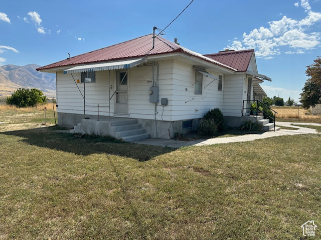 View of side of home with a yard