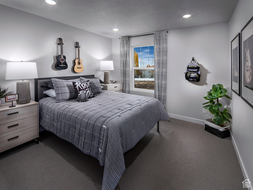 Bedroom featuring a textured ceiling and dark carpet