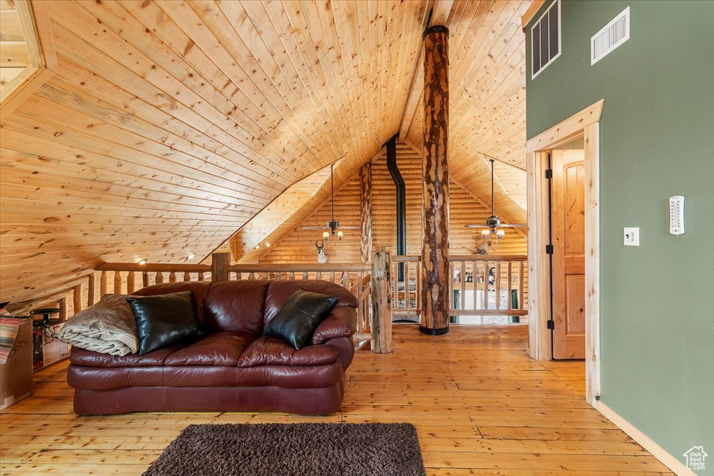 Living room featuring wood walls, wooden ceiling, high vaulted ceiling, hardwood / wood-style flooring, and ceiling fan