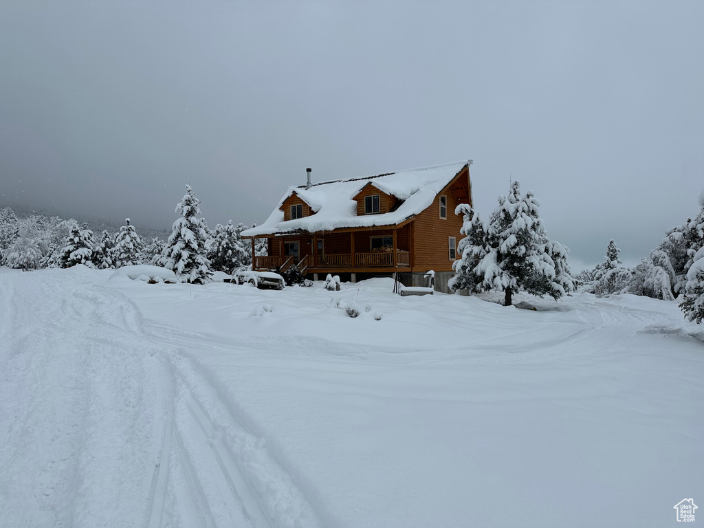 View of snow covered exterior with a wooden deck