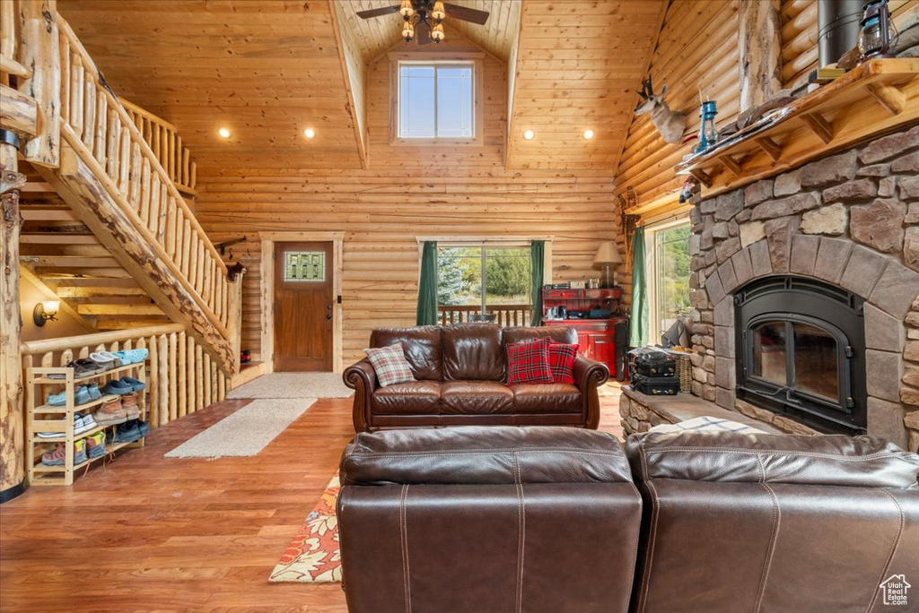 Living room with a fireplace, hardwood / wood-style flooring, high vaulted ceiling, and ceiling fan