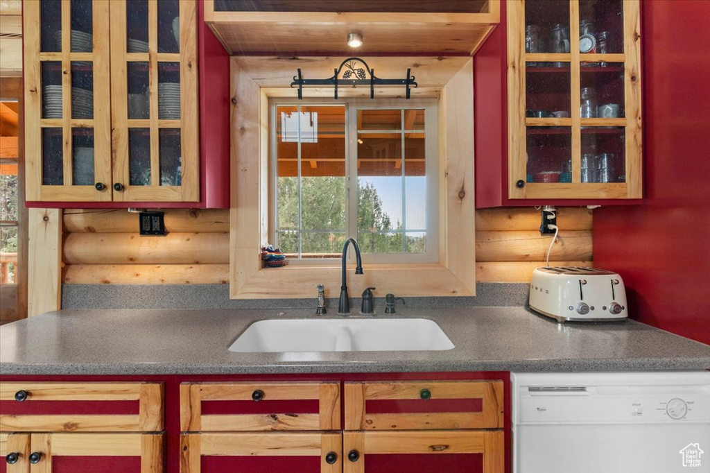 Kitchen with dishwasher, log walls, and sink